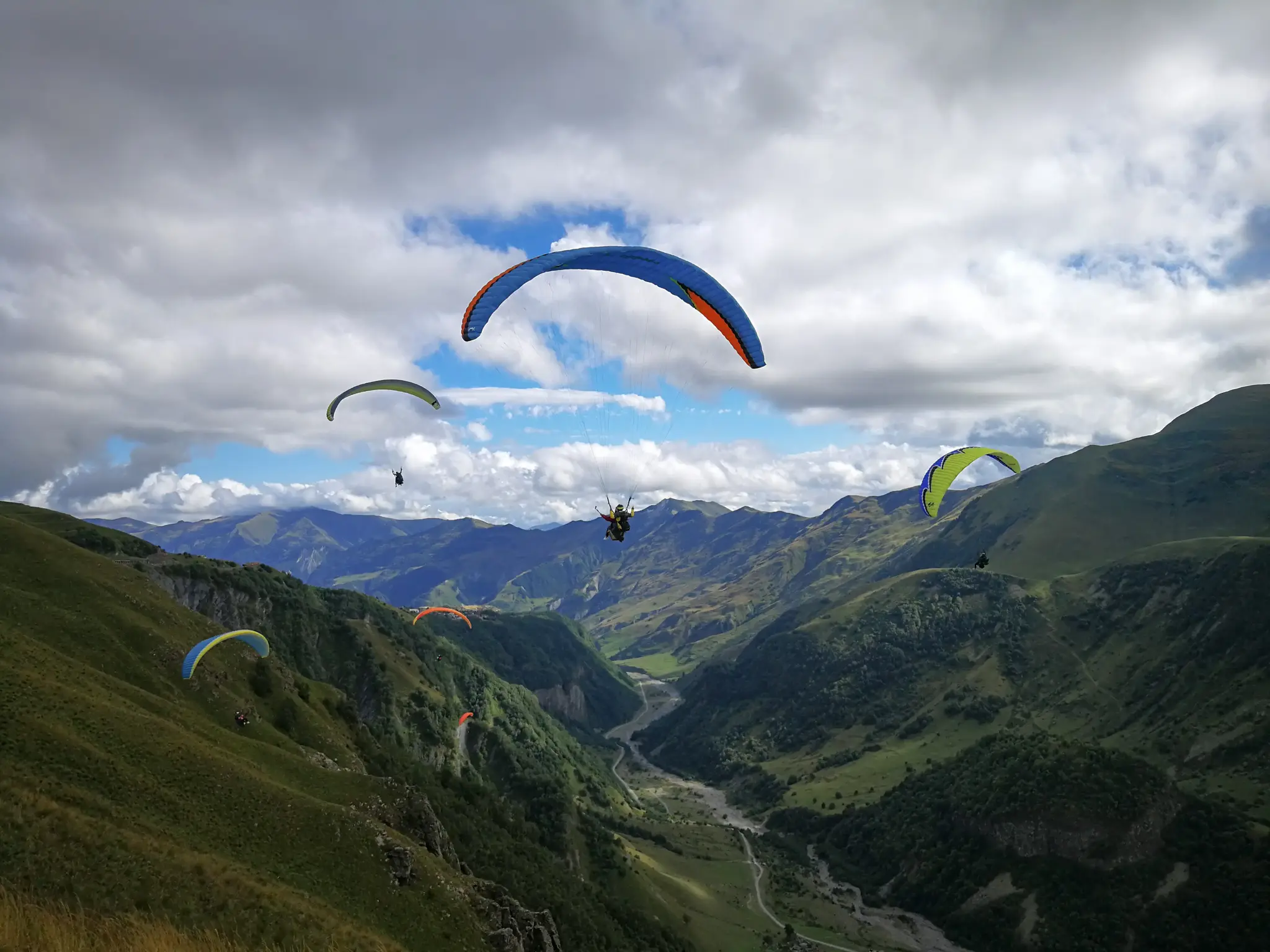 Acrobatic paraglider in a steep spiral against a blue sky