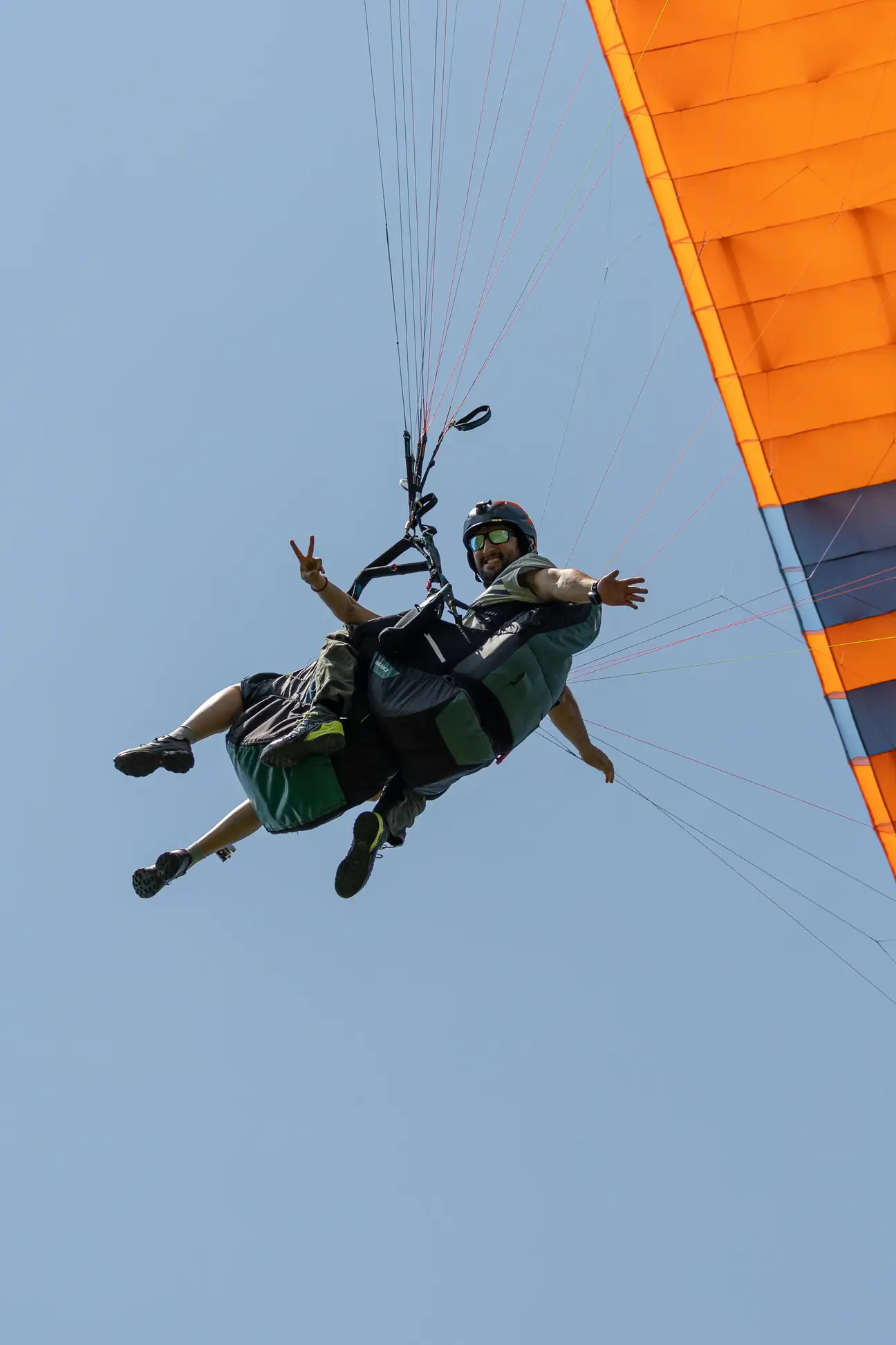 Smiling passenger during a tandem flight over green valleys