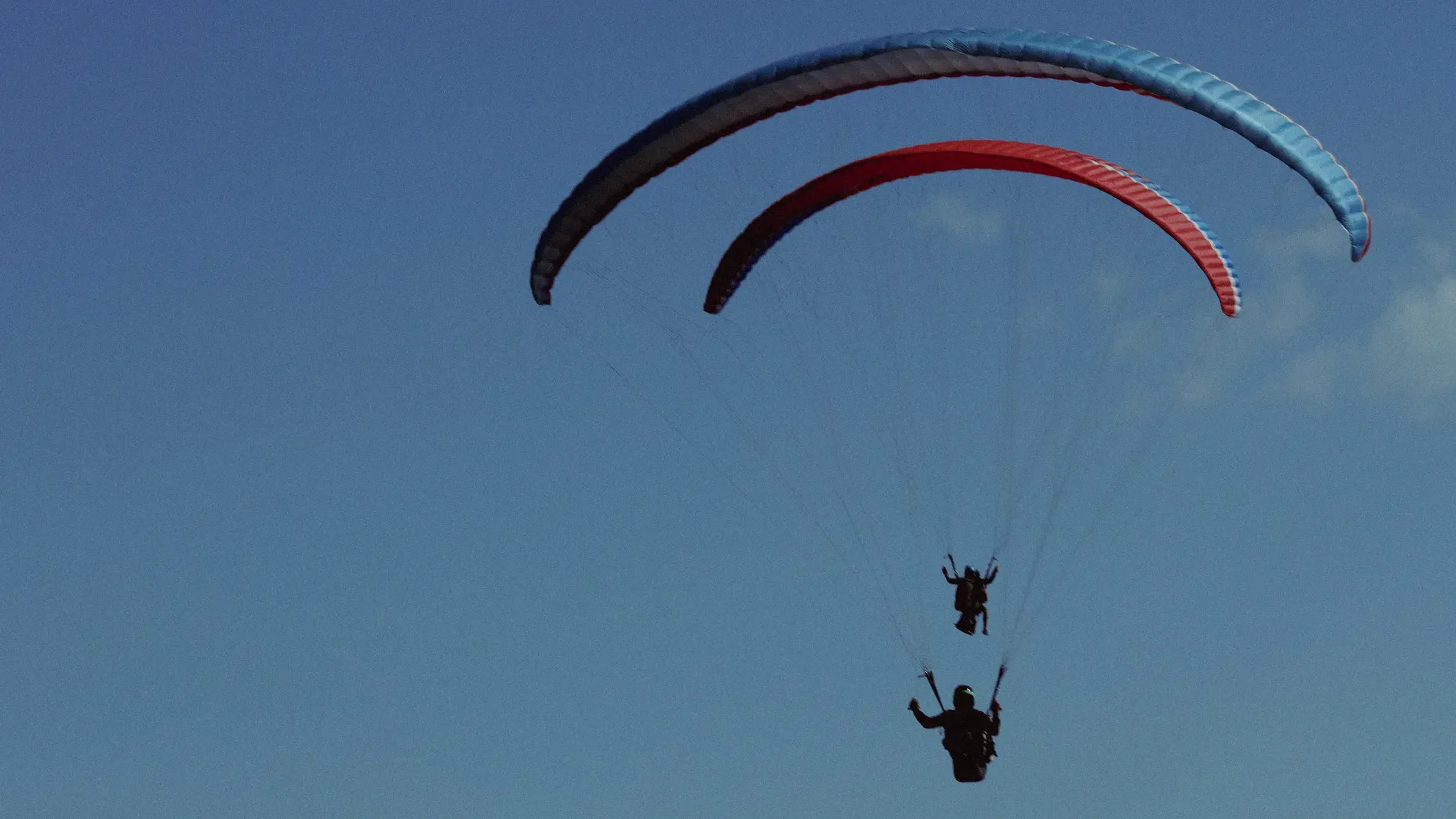 Paraglider silhouette at sunset over the Caucasus ridges