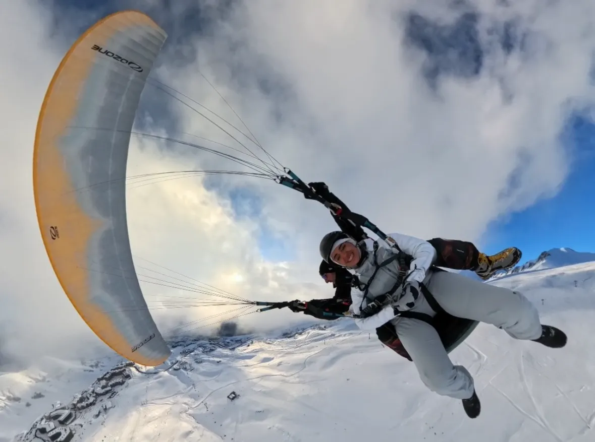 Paraglider flying over the snowy ski slopes of Gudauri in winter